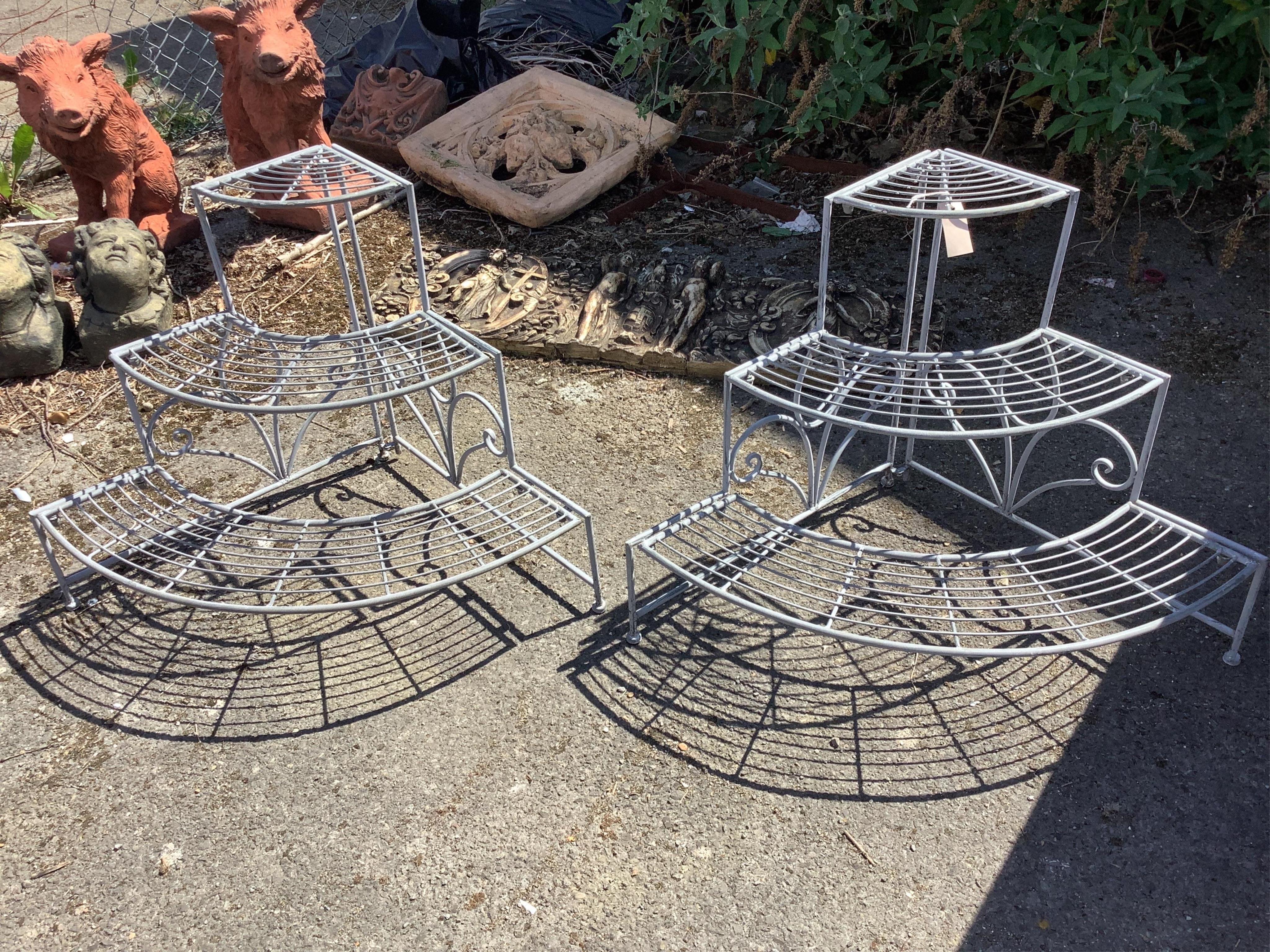 A pair of Victorian style painted metal three tier corner pot stands, each width 83cm, depth 59cm, height 60cm